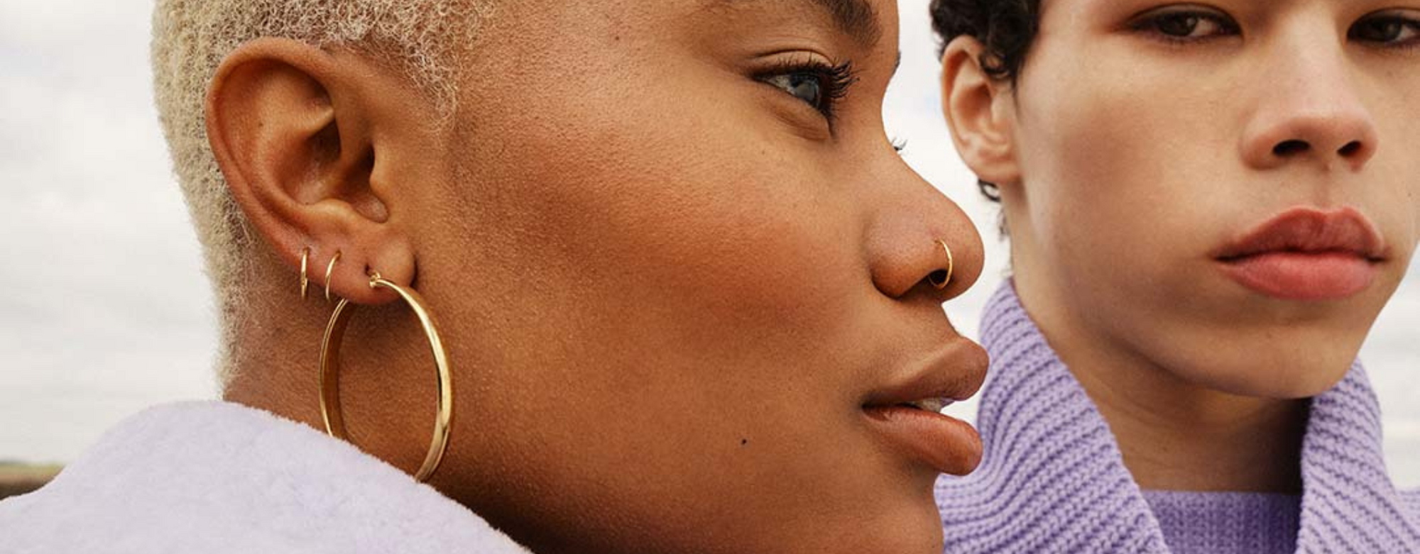 Photo of two people with ear piercings and nose piercings. 